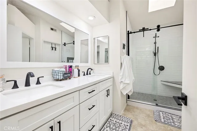a bathroom with a double sink shower and a mirror