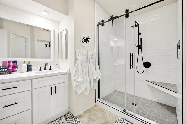 a bathroom with a shower sink and mirror