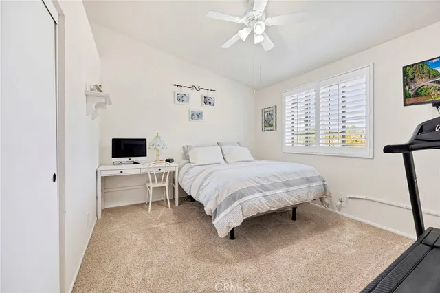 a spacious bedroom with a bed and a flat screen tv