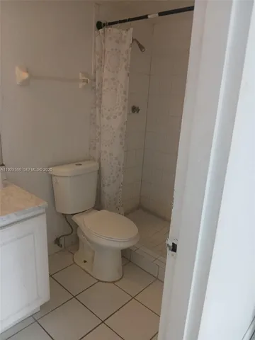 a white toilet sitting next to a shower