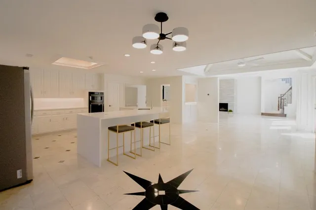 a view of a livingroom with a chandelier a ceiling fan and window