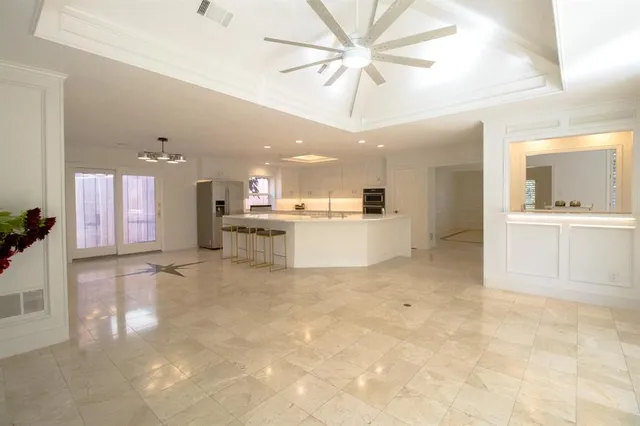 a view of an empty room with a fireplace and a fan
