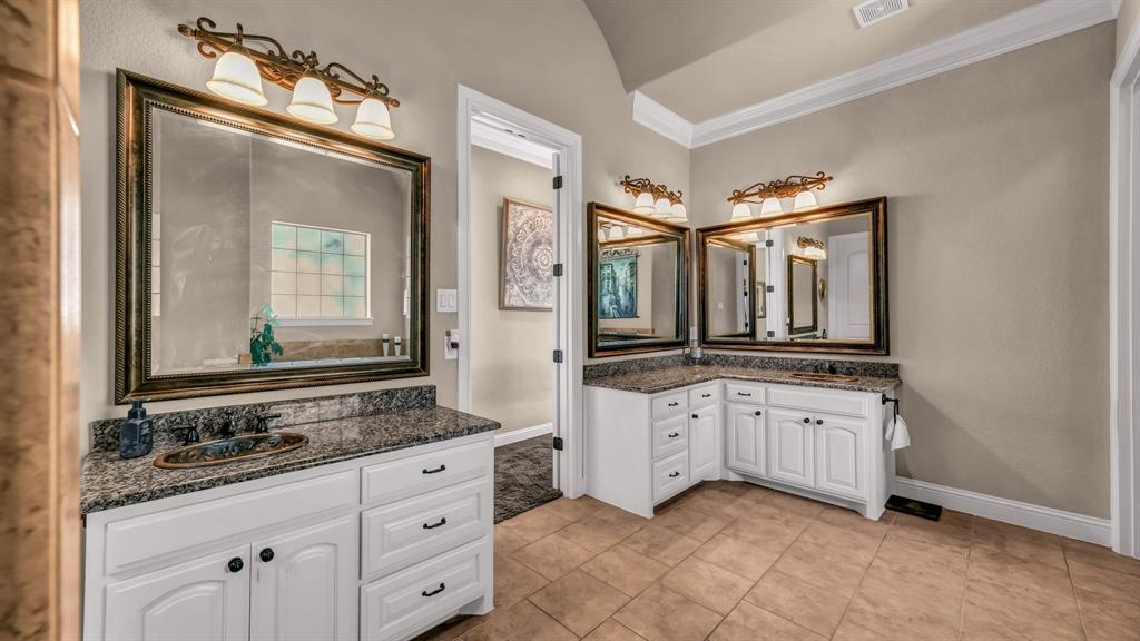 840 Hensley Road Gordon, TX 76453 - Photo 25 of 40 Bathroom with crown molding, visible vents, baseboards, two vanities, and a sink