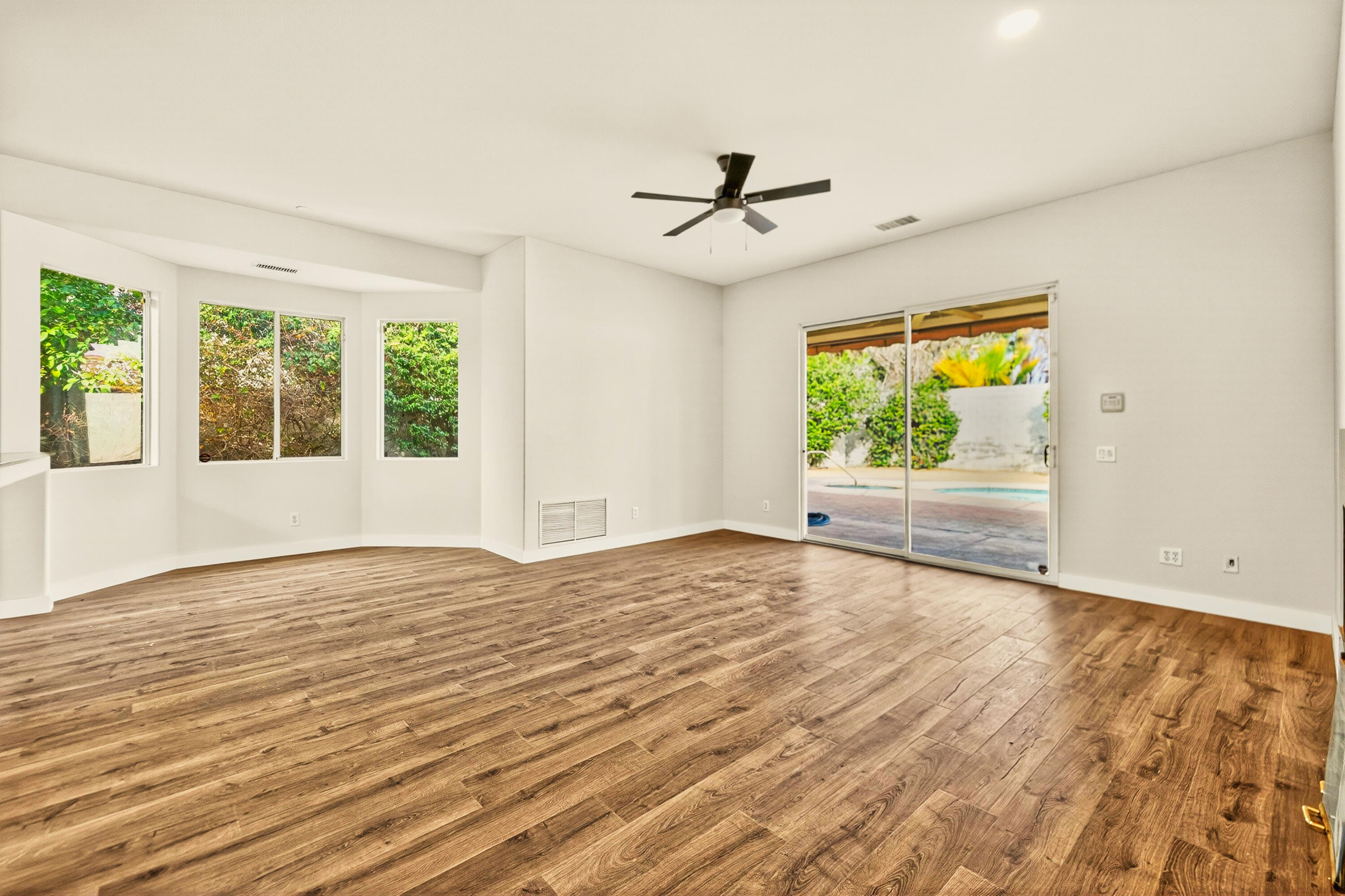 6 Queens Court Rancho Mirage, CA 92270 - Photo 17 of 28 a view of an empty room with a window and wooden floor