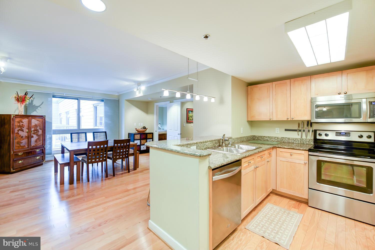 777 7th Street Northwest, Unit 1113 Washington, DC 20001 - Photo 1 of 30 a kitchen with lots of white cabinets appliances and furniture