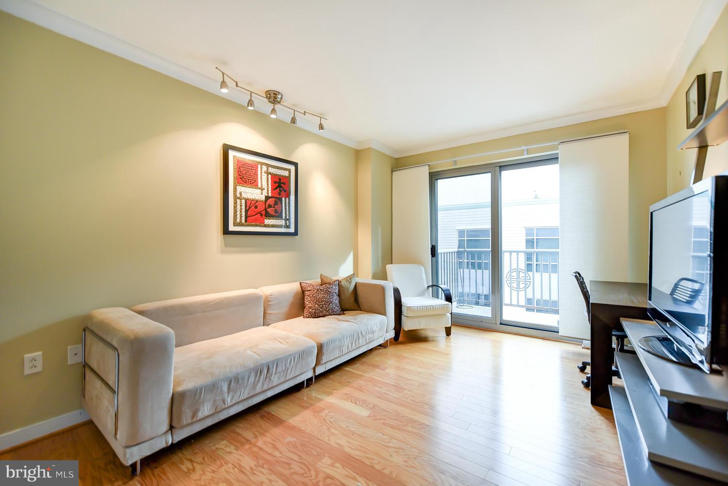 777 7th Street Northwest, Unit 1113 Washington, DC 20001 - Photo 18 of 30 a living room with furniture and a flat screen tv