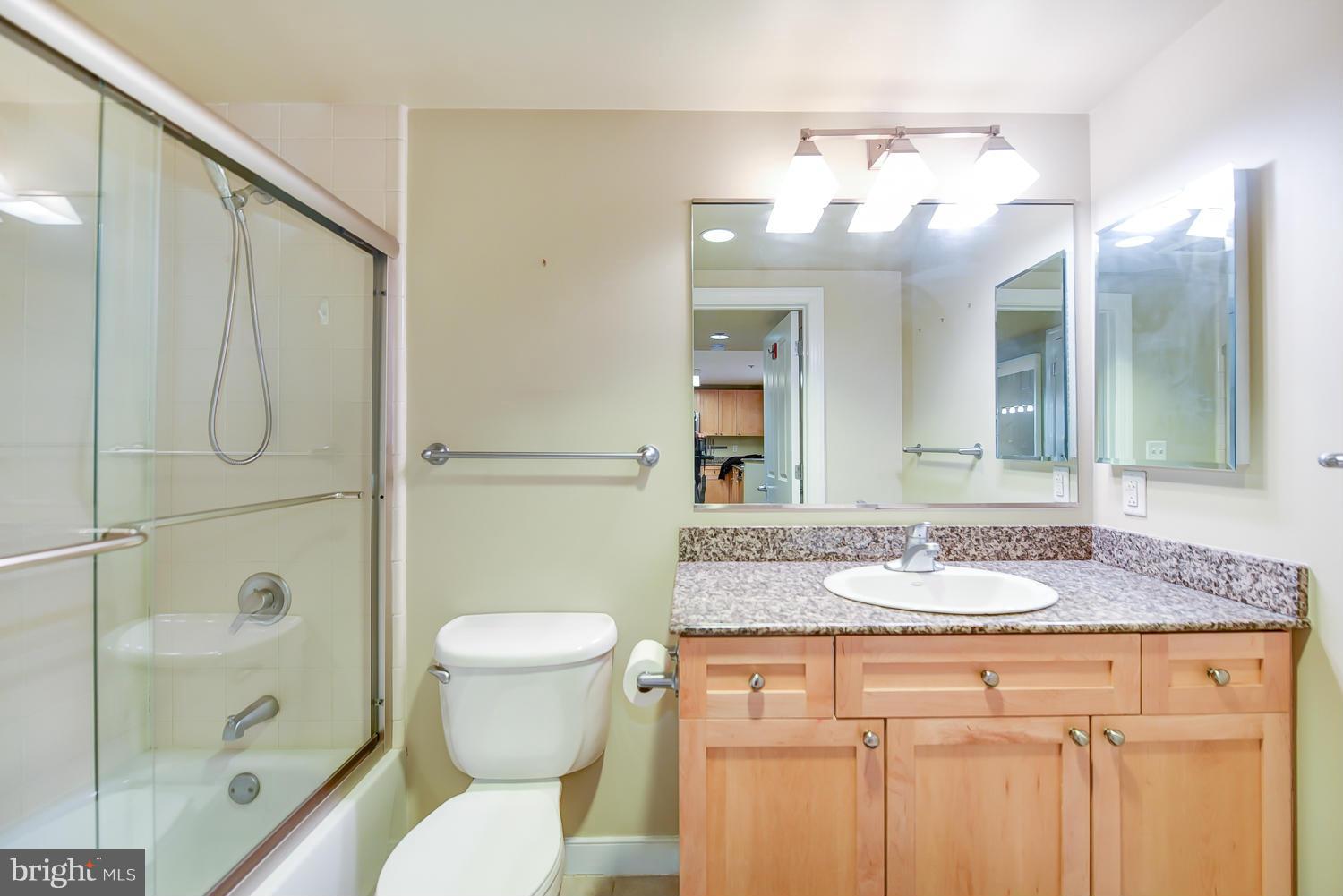 777 7th Street Northwest, Unit 1113 Washington, DC 20001 - Photo 20 of 30 a bathroom with a granite countertop sink toilet and shower