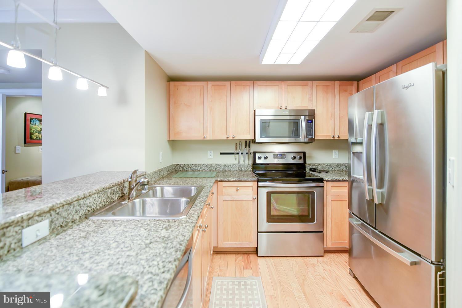 777 7th Street Northwest, Unit 1113 Washington, DC 20001 - Photo 5 of 30 a kitchen with granite countertop a refrigerator stove and microwave