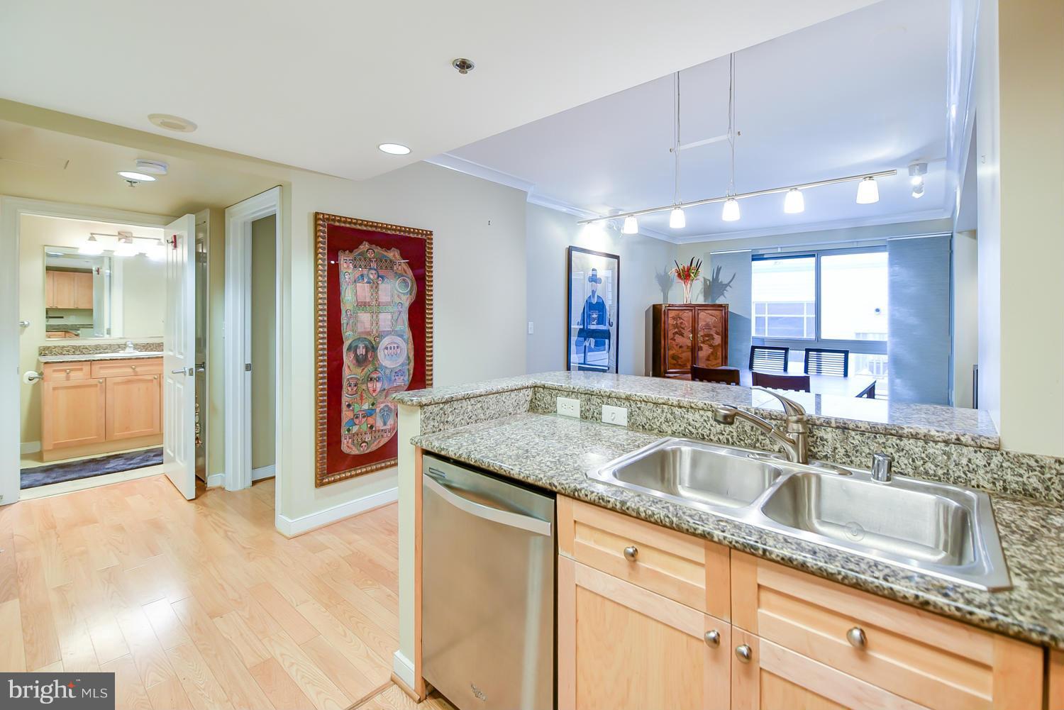777 7th Street Northwest, Unit 1113 Washington, DC 20001 - Photo 6 of 30 a kitchen with stainless steel appliances granite countertop a sink and a refrigerator