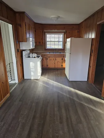 a view of a kitchen with wooden floor and electronic appliances