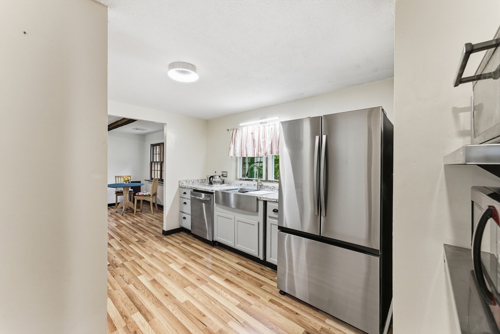 193 Roy Street Springfield, MA 01104 - Photo 11 of 40 a kitchen with a refrigerator a sink and chairs