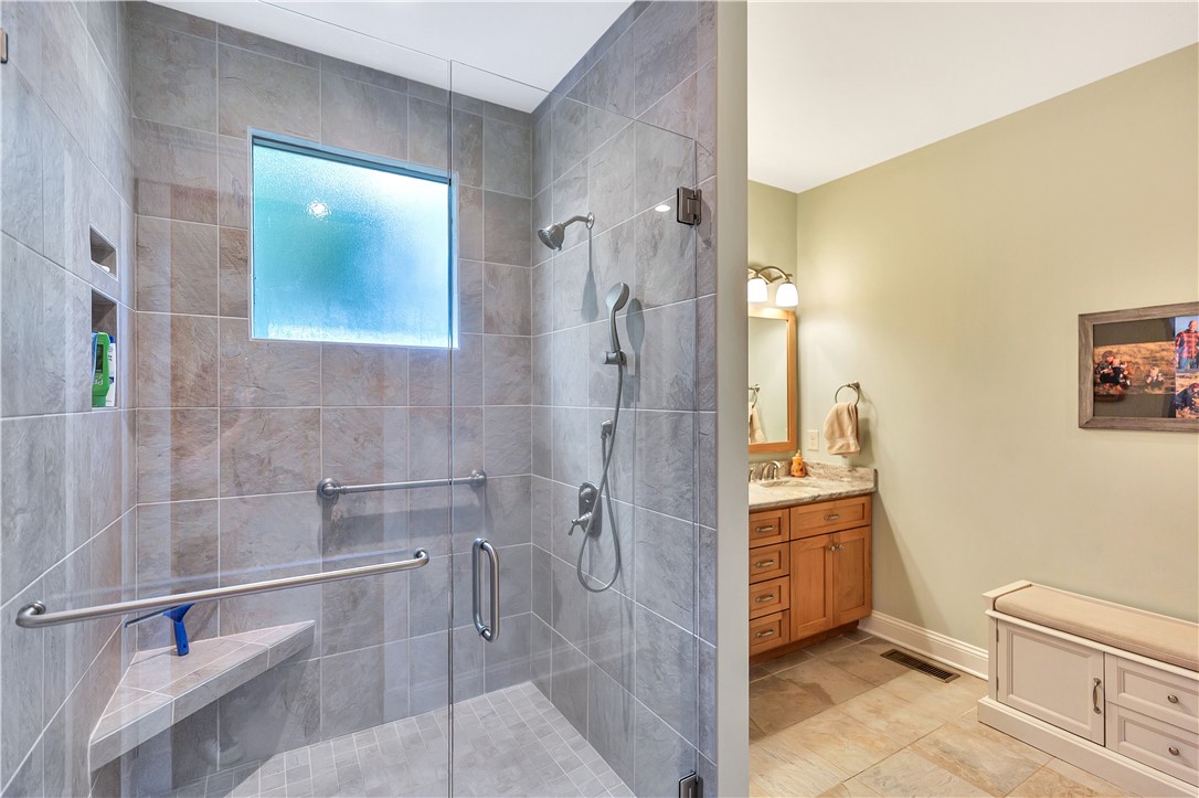10 Admiral Lane Salem, SC 29676 - Photo 23 of 43 This primary bathroom boasts a tiled shower with a built-in bench and a separate vanity area.