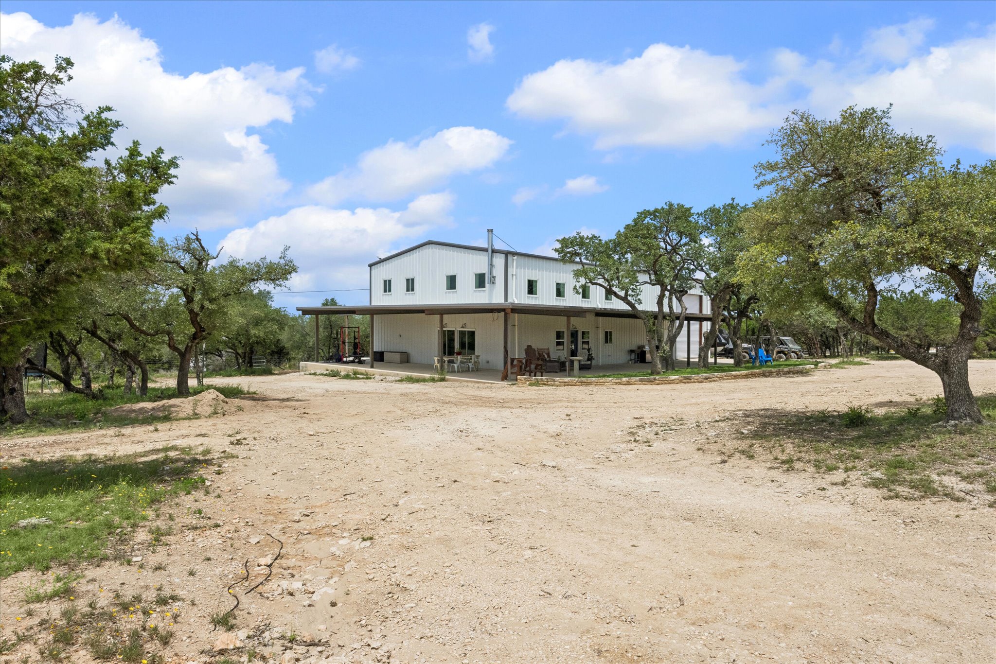 6411 West Fitzhugh Road Dripping Springs, TX 78620 - Photo 5 of 34 Two-story barndo with a covered porch and an attached workshop.