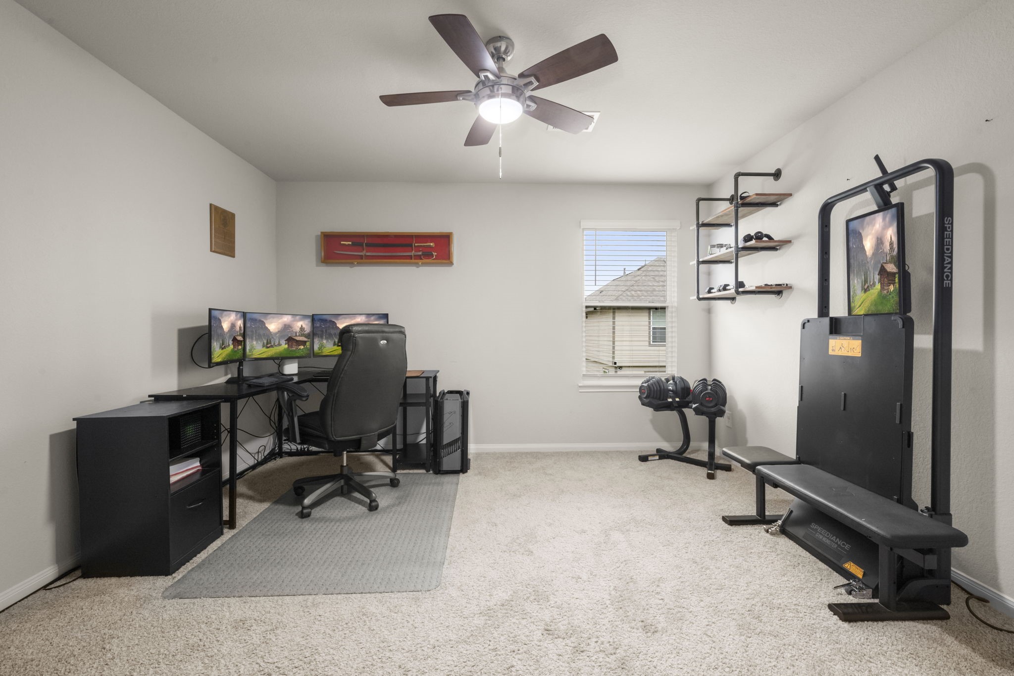 4915 Blue Jacaranda Way Spring, TX 77373 - Photo 22 of 30 Bedroom 4 - Currently used as a home office/workout space, this room features a ceiling fan, plush carpet, wall-mounted shelves and a window overlooking the backyard.