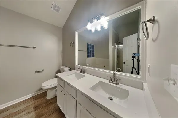 a bathroom with a sink and mirror with toilet