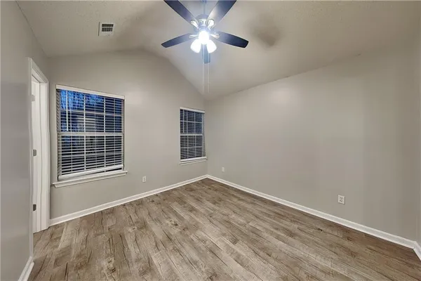 a view of an empty room with a window and a ceiling fan