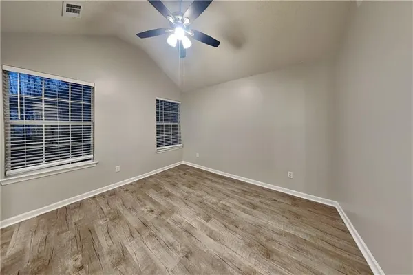 a view of an empty room with a window and a chandelier fan