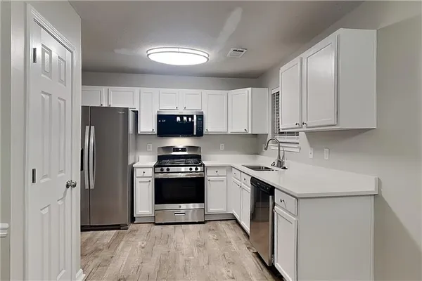 a kitchen with stainless steel appliances a refrigerator stove and sink