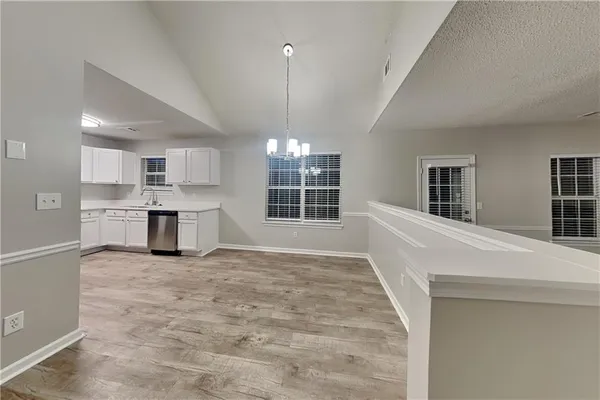 a view of kitchen with granite countertop cabinets and window