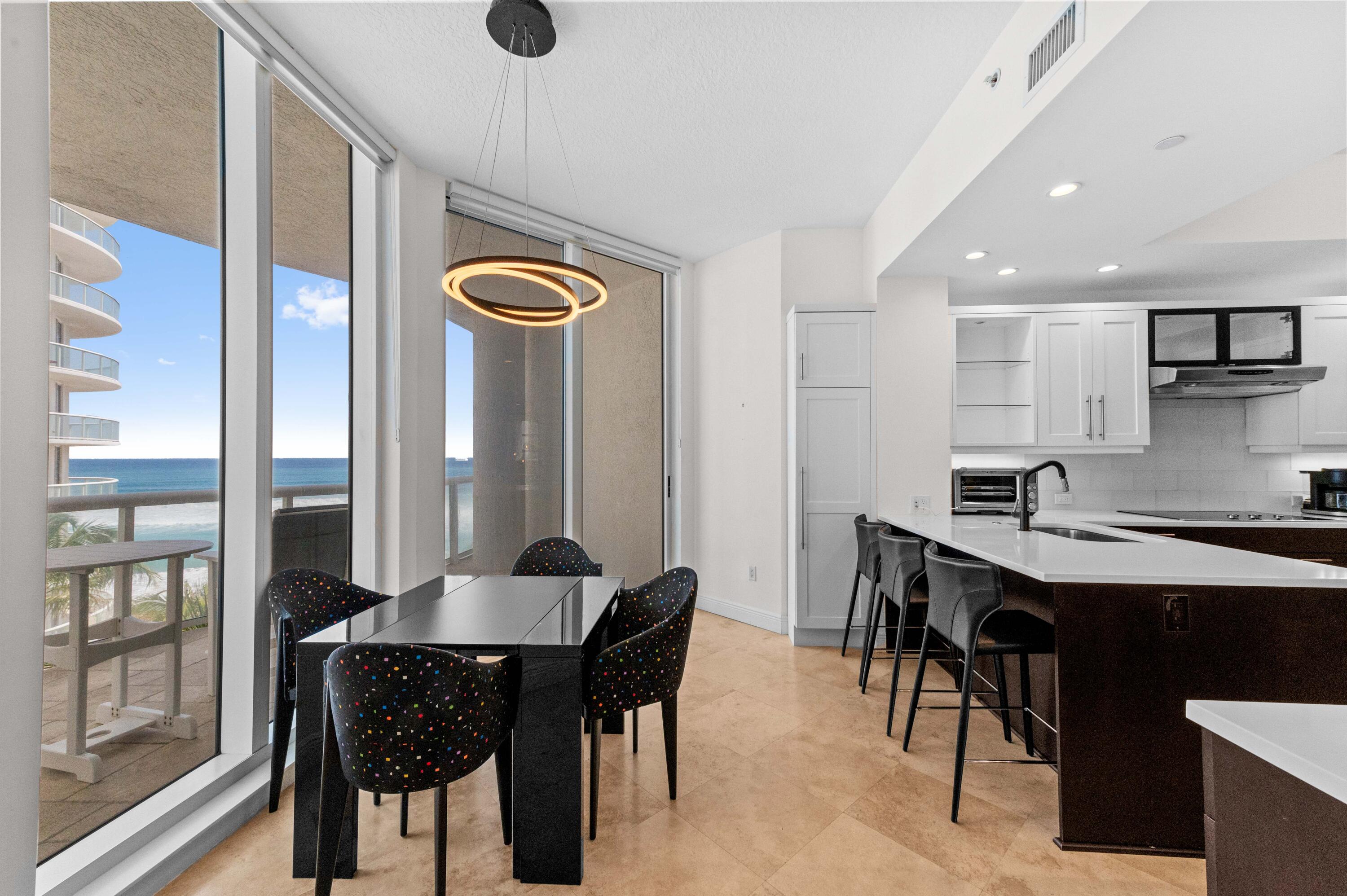 4600 North Ocean Drive, Unit 605 Riviera Beach, FL 33404 - Photo 13 of 65 a kitchen with a table chairs and a refrigerator