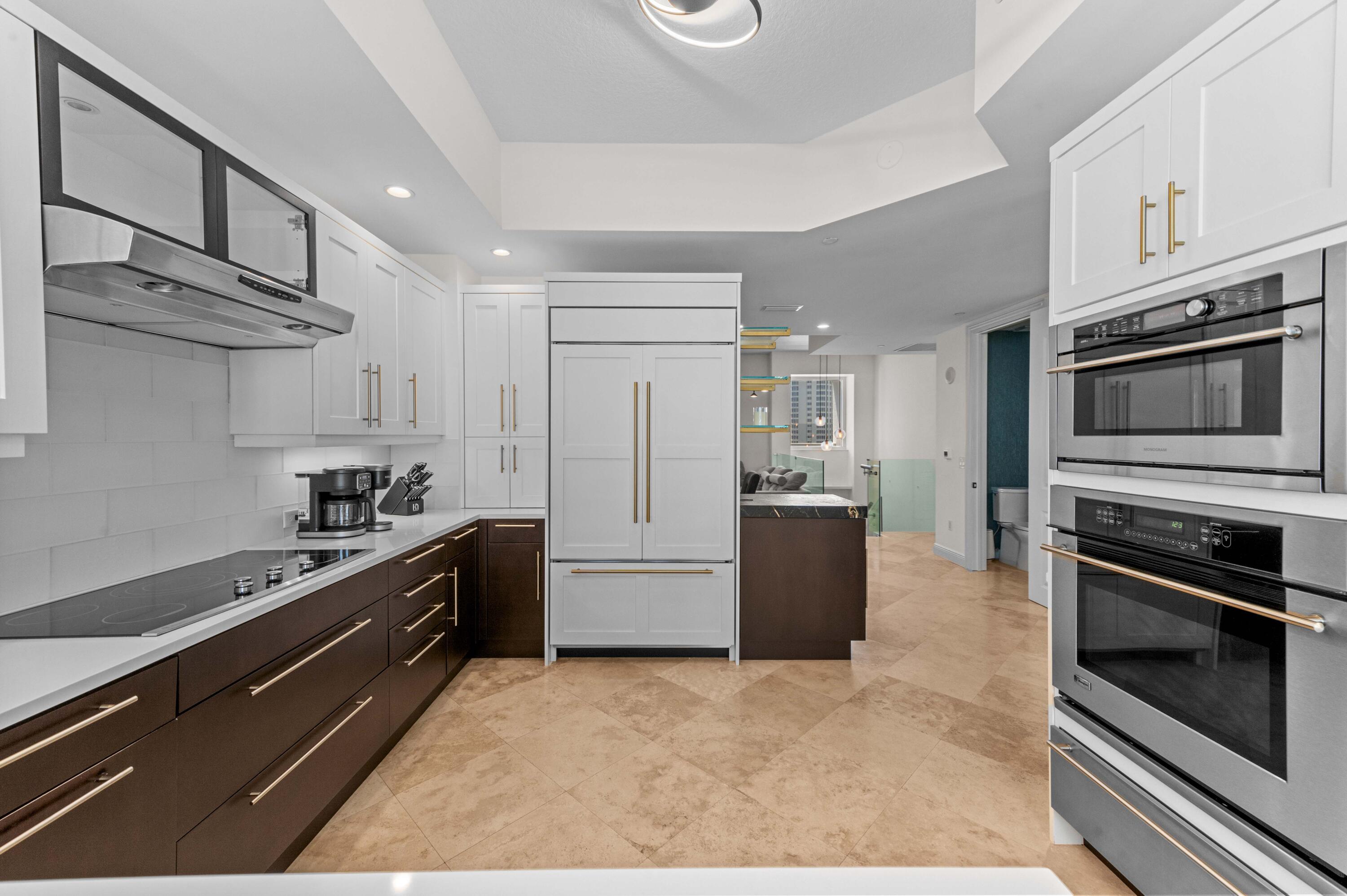 4600 North Ocean Drive, Unit 605 Riviera Beach, FL 33404 - Photo 14 of 65 a kitchen with granite countertop a stove microwave and refrigerator