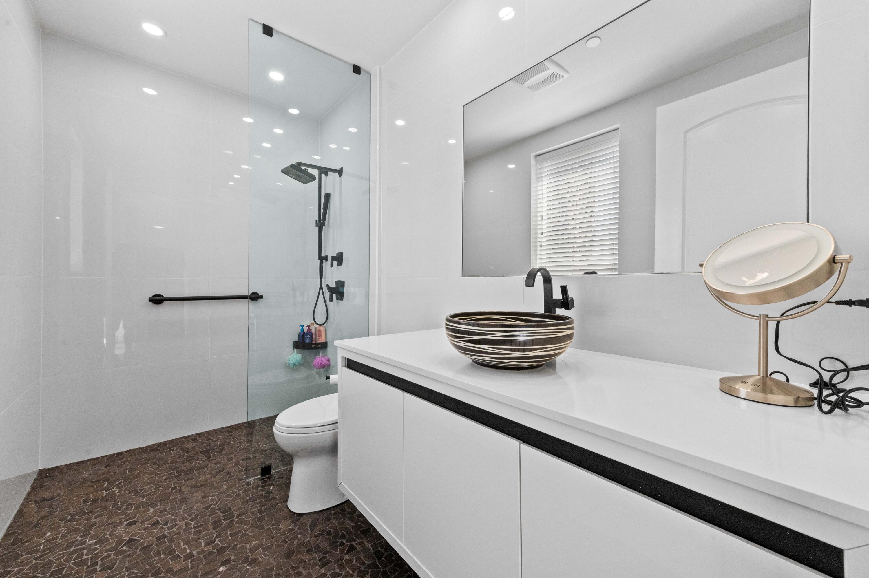 4600 North Ocean Drive, Unit 605 Riviera Beach, FL 33404 - Photo 30 of 65 a bathroom with a sink a toilet and a mirror