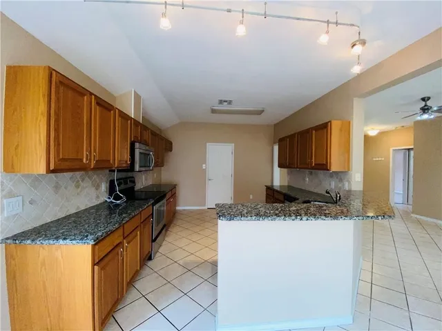 a kitchen with stainless steel appliances granite countertop a sink stove and cabinets
