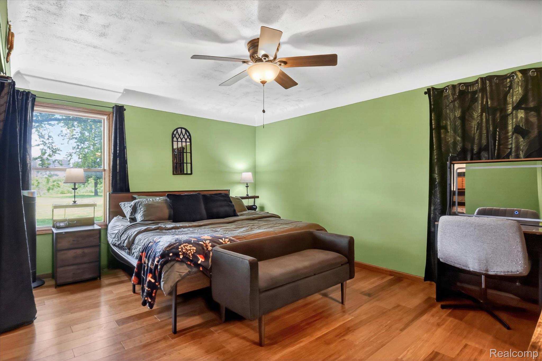 3949 West Burns Line Road Brown City, MI 48416 - Photo 25 of 70 Spacious bedroom featuring wood-finish flooring, a ceiling fan with integrated lighting, and a large window