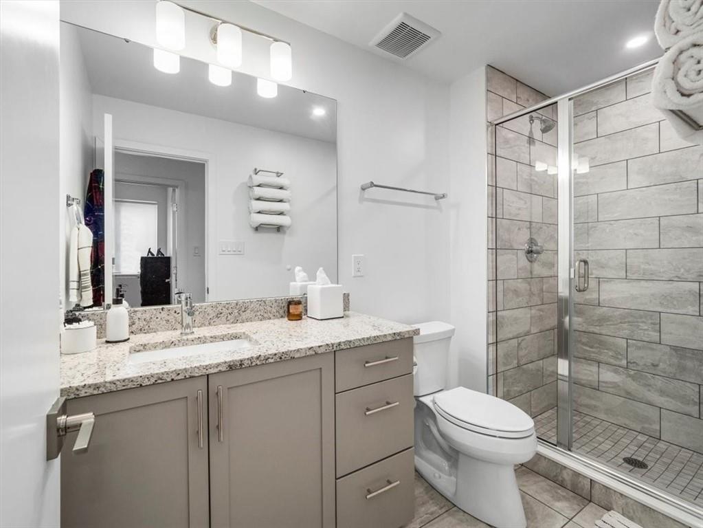 5557 Berlin Way Pittsburgh, PA 15201 - Photo 6 of 34 a bathroom with a granite countertop sink toilet a mirror a vanity and shower