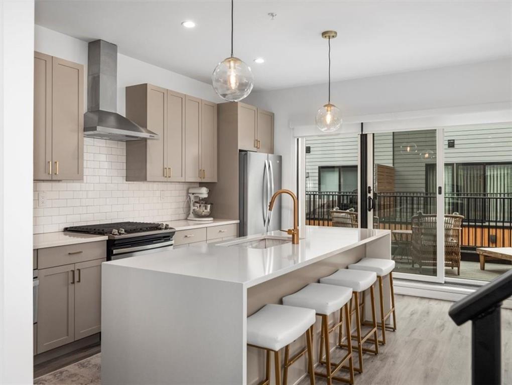 5557 Berlin Way Pittsburgh, PA 15201 - Photo 10 of 34 a kitchen with stainless steel appliances granite countertop a stove refrigerator a sink dishwasher a dining table and chairs with wooden floor