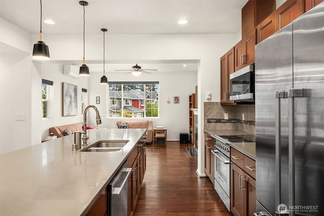 a kitchen with stainless steel appliances granite countertop a sink a stove and a refrigerator