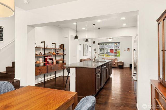 a kitchen with stainless steel appliances kitchen island granite countertop a table chairs and a refrigerator