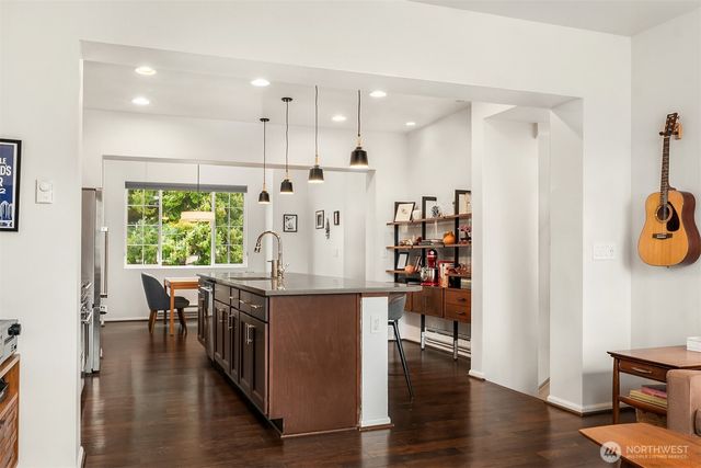 an open kitchen with wooden floor and large window