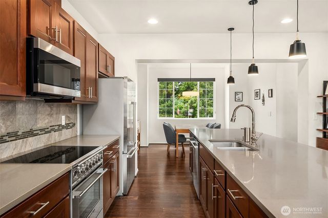 a kitchen with a sink a counter space appliances and cabinets