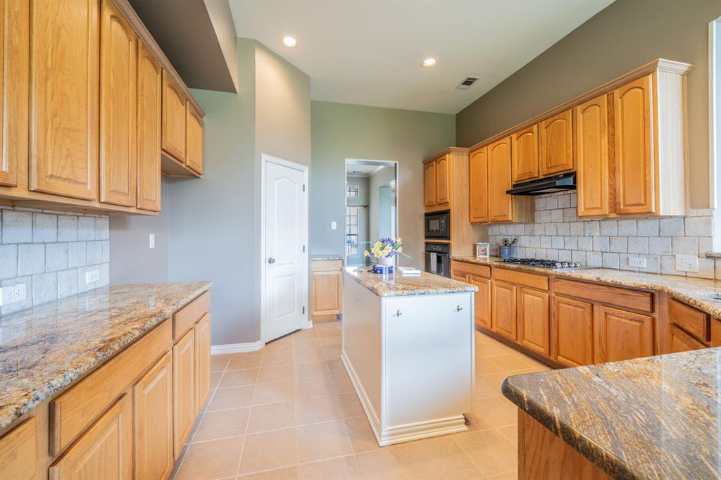 7517 Rodeo Drive Denton, TX 76208 - Photo 15 of 39 Gleaming granite counters, island, walk-in pantry, wall oven and microwave, gas cooktop -- and open space for you to view activities in the breakfast room, living room, or back yard.