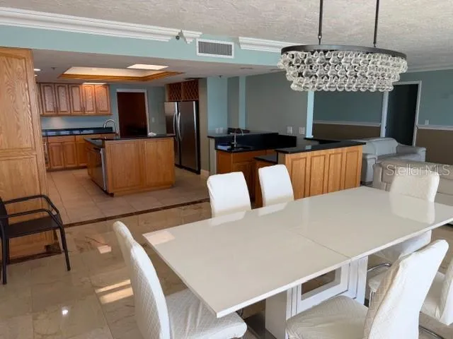 a living room with furniture a kitchen view and a chandelier