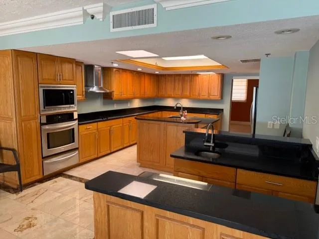 a kitchen with stainless steel appliances kitchen island granite countertop a sink and cabinets