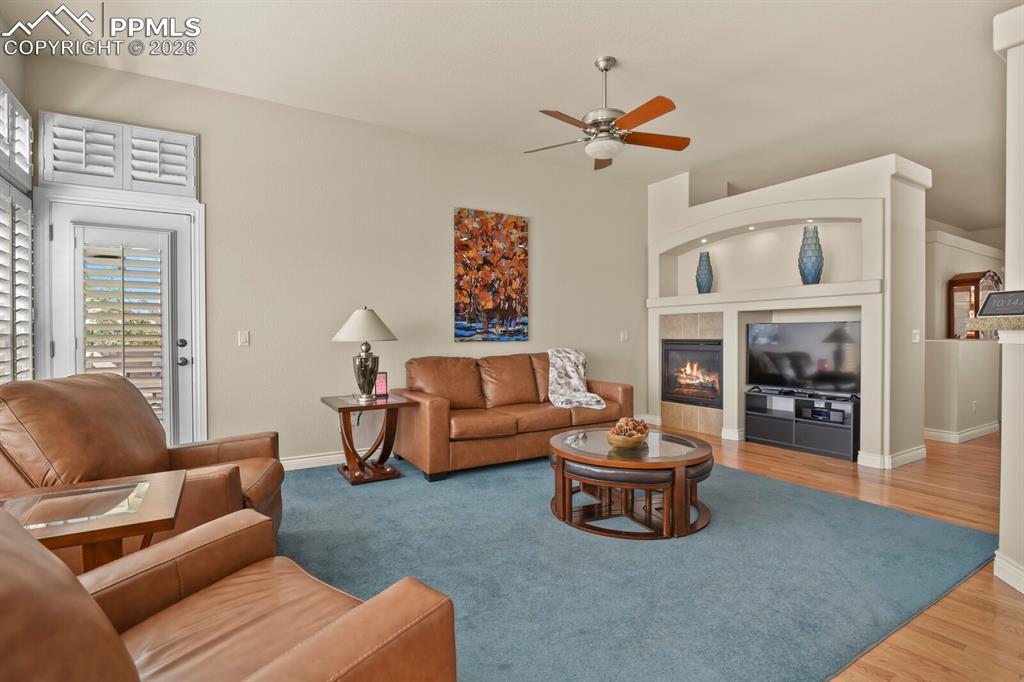 617 Concerto Drive Colorado Springs, CO 80906 - Photo 13 of 46 Living area featuring a ceiling fan, a fireplace with a decorative mantel, and light-colored walls