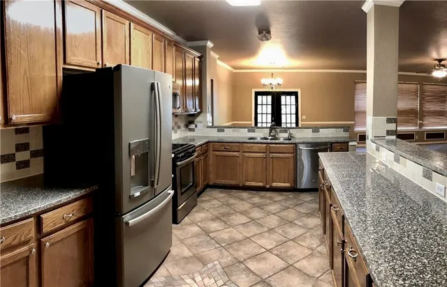 a kitchen with stainless steel appliances granite countertop a sink stove and refrigerator