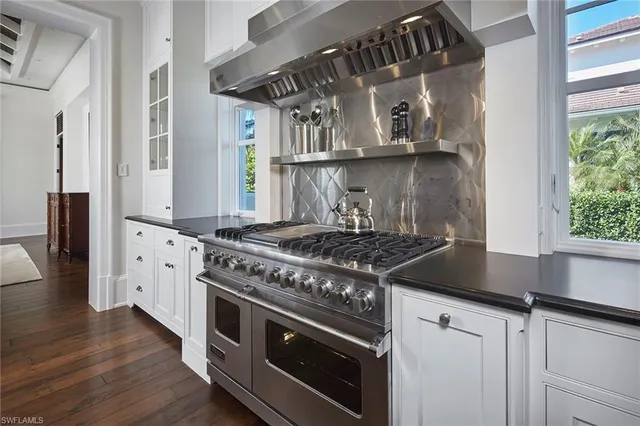 a kitchen with stainless steel appliances granite countertop a stove oven and a wooden floors