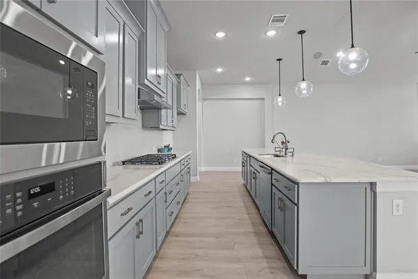 a kitchen with stainless steel appliances a sink stove and cabinets