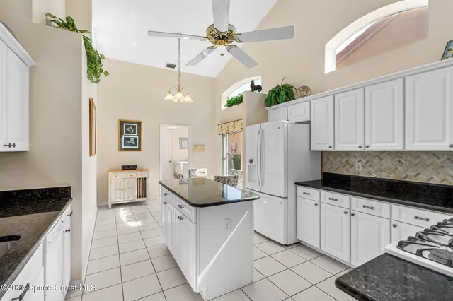 a kitchen with white cabinets and appliances