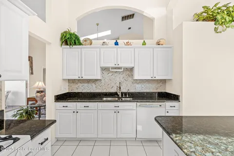 a kitchen with granite countertop a sink and cabinets