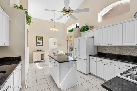 a kitchen with white cabinets and appliances
