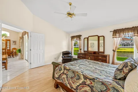 a bedroom with a bed a chandelier and dresser