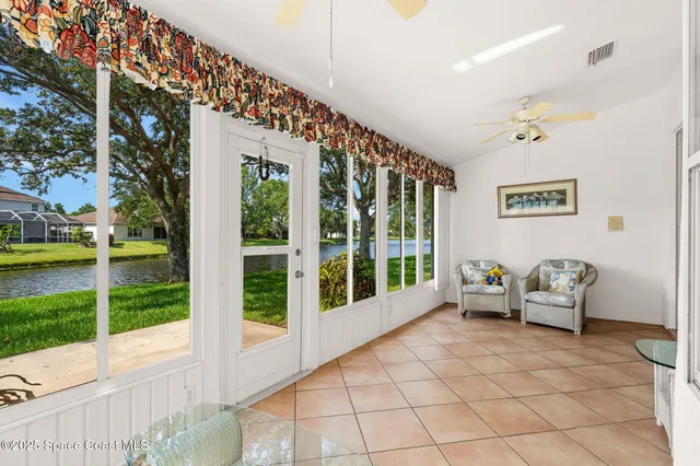a living room with furniture floor to ceiling window and a table