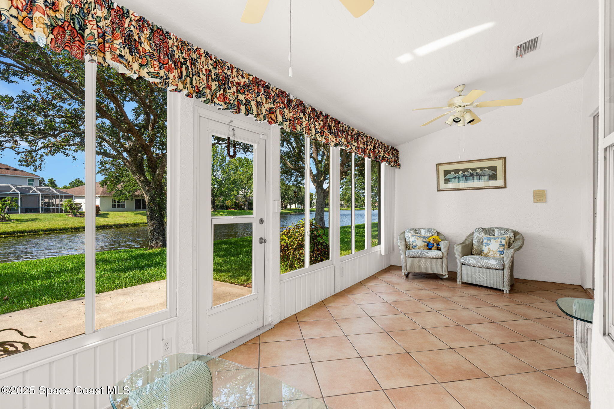 7702 Candlewick Drive Melbourne, FL 32940 - Photo 26 of 37 a living room with furniture floor to ceiling window and a table