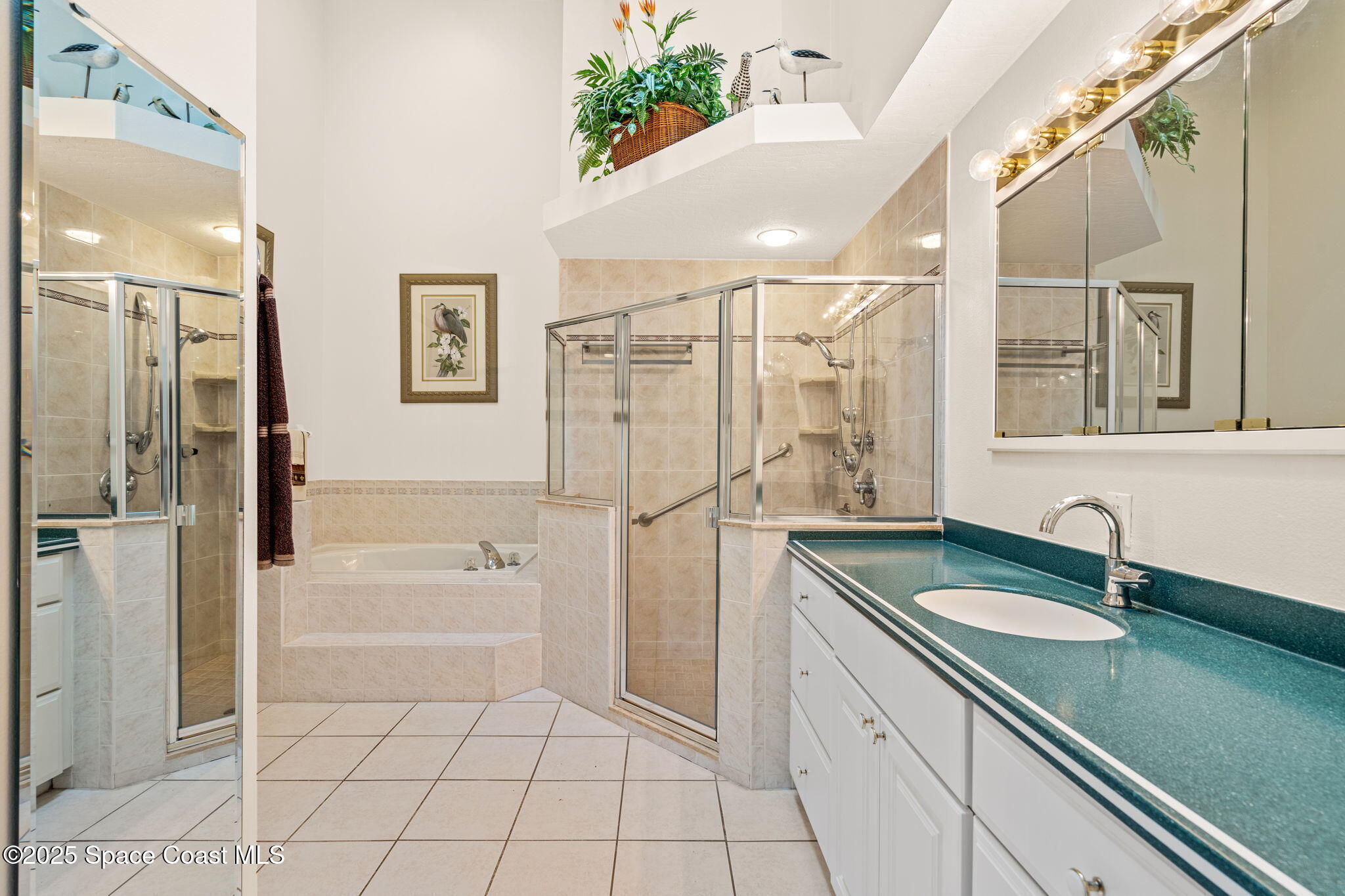 7702 Candlewick Drive Melbourne, FL 32940 - Photo 4 of 37 a bathroom with a sink a large mirror and a bathtub