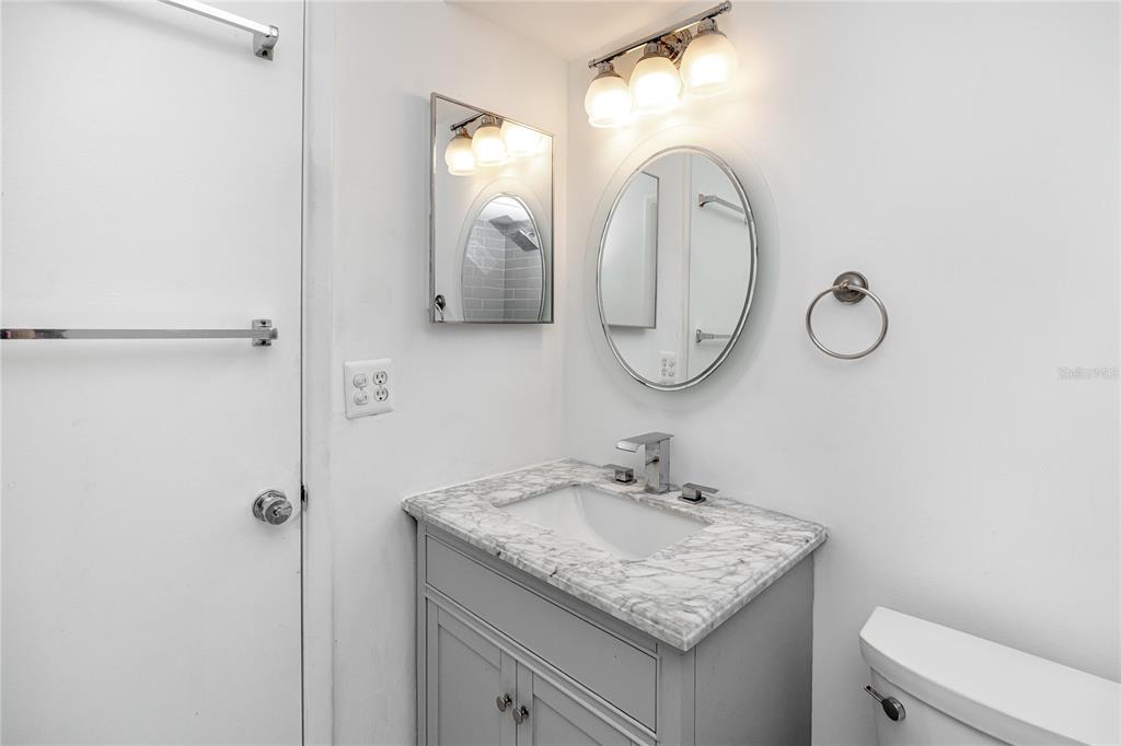 2207 Belleair Road, Unit B4 Clearwater, FL 33764 - Photo 28 of 37 a bathroom with a granite countertop sink vanity mirror and toilet