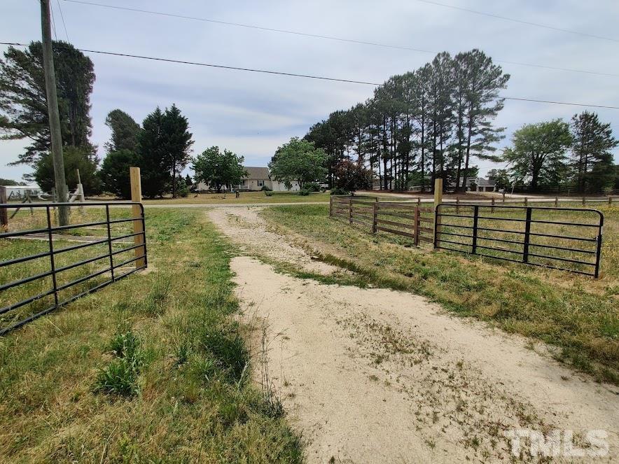 a view of a yard with wooden fence
